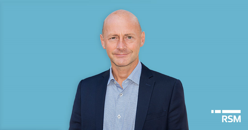 Man in suit in front of blue background